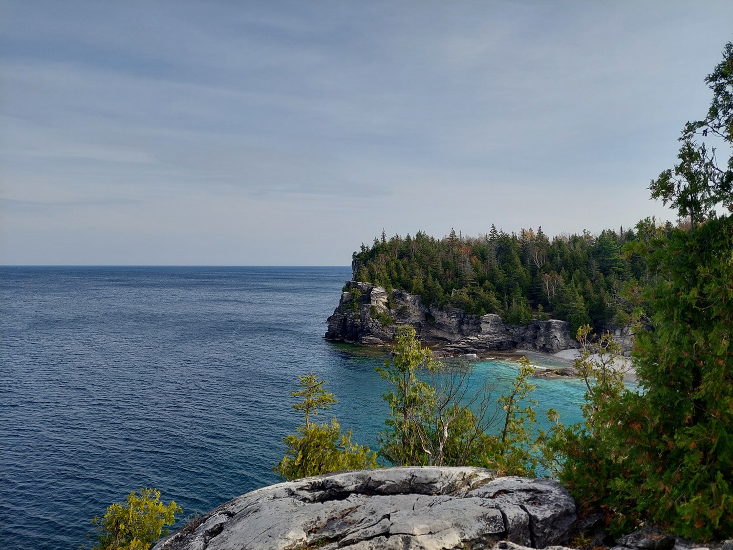 Falaise rocheuse au bord d’une eau d’un bleu éclatant.