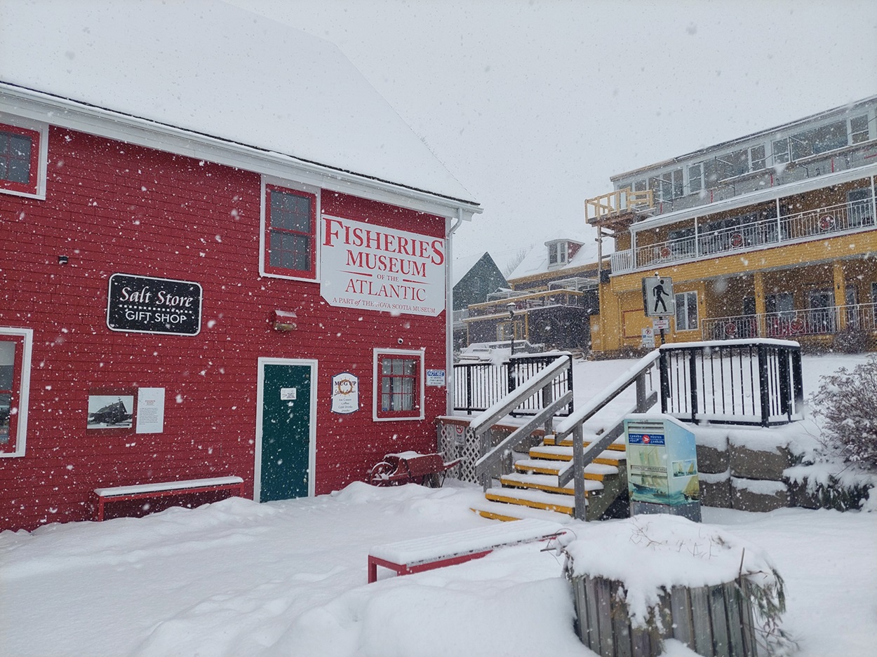 Red building surrounded by falling snow.