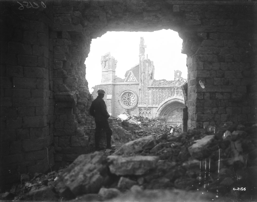 A Canadian soldier looking through the south entrance of the Cathedral in Ypres, 1917.