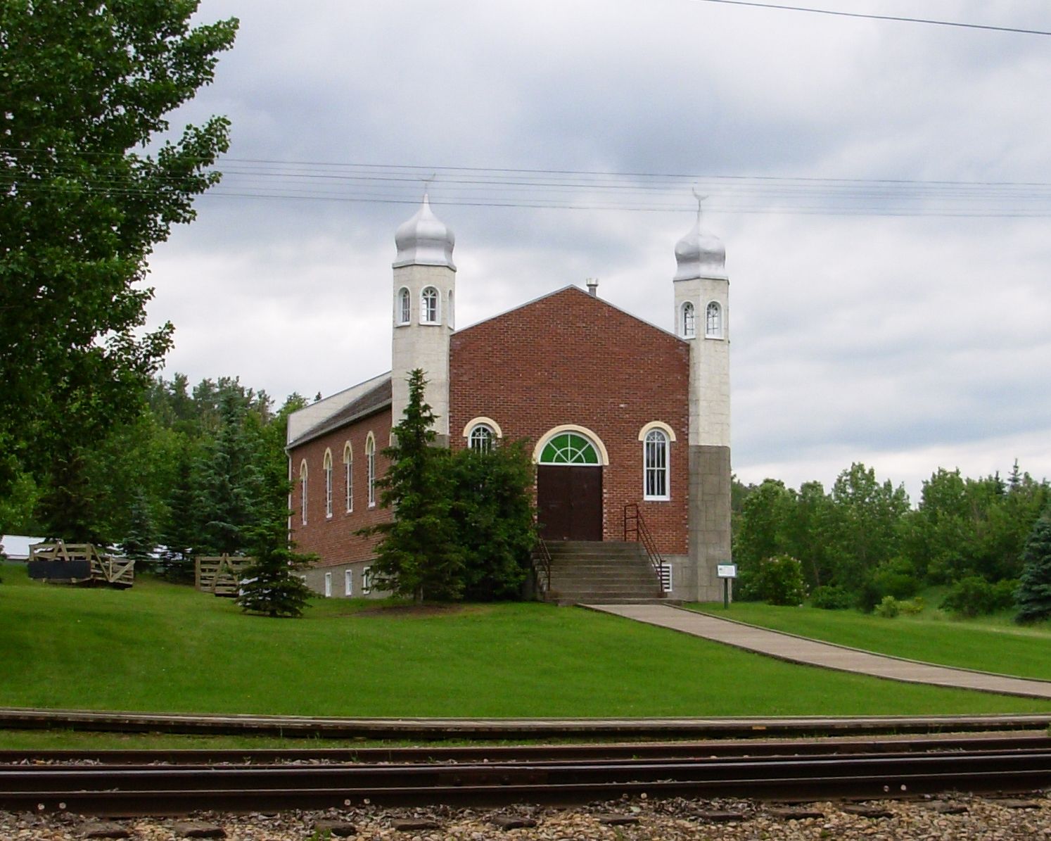A red-bricked mosque with two minarets.